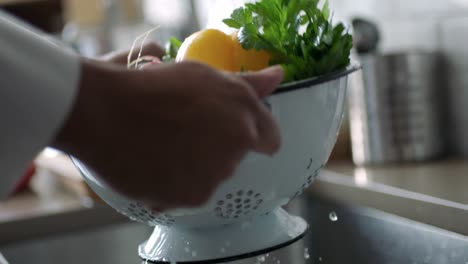 person rinsing some vegetables in a strainer