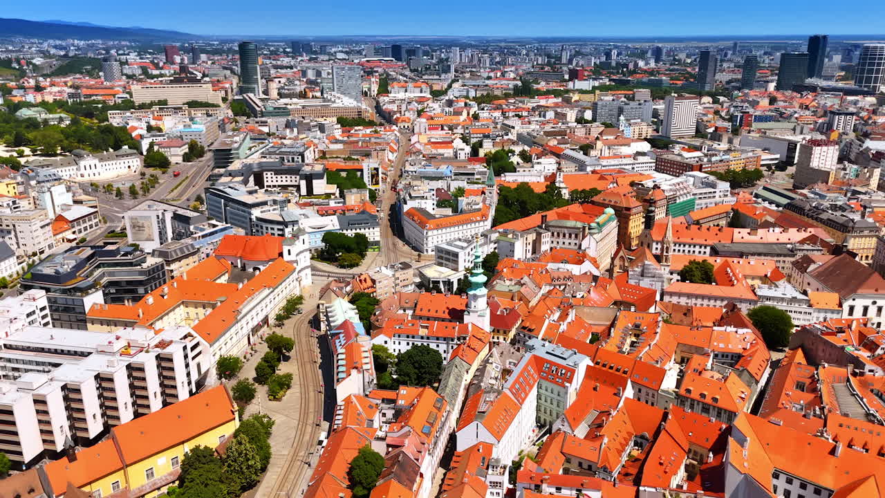 Orange roofs of the old town reflect bright sun. Urban landscape of the historical part of Bratislava, Slovakia from drone