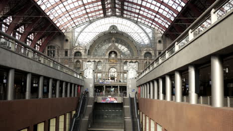 static wide shot of beautiful central train station with different level tracks and flying pigeons in antwerp,belgium