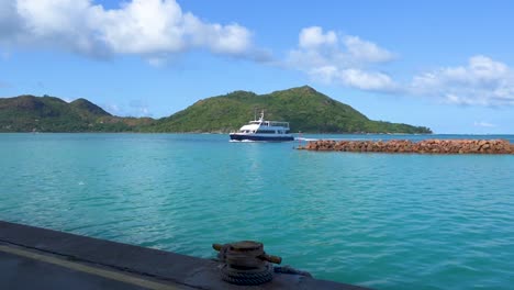 inter island ferry coming into dock in the seychelles with coastline in the background