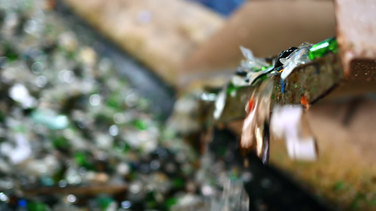 Process of sorting glass garbage on a vibrating conveyor belt at waste sorting plant. Slow motion