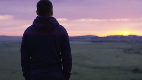 hombre contemplando el amanecer sobre el campo