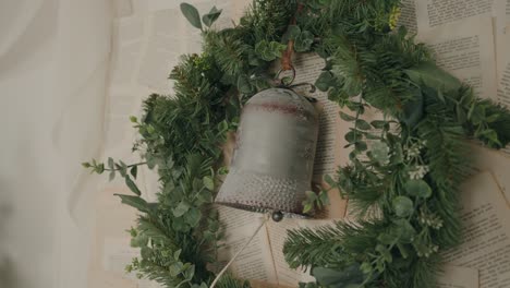 christmas wreath with bell decoration on a backdrop of vintage pages for a festive touch