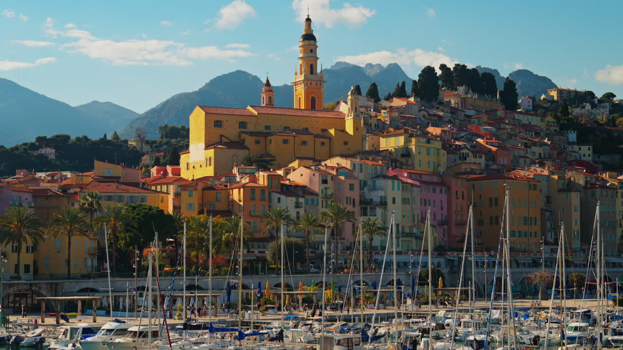 Distant view of the St Michel Basilica surrounded by colourful buildings, Menton, France