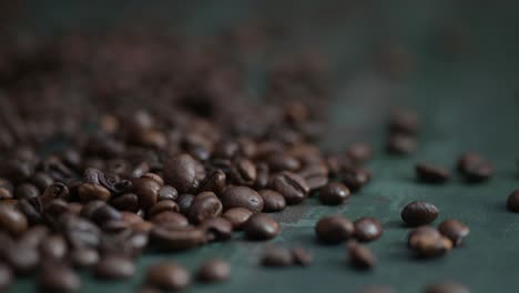 Dolly-left-of-coffee-beans-lying-on-the-dark-green-background