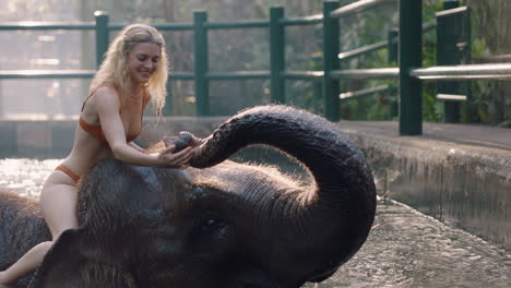 beautiful-woman-riding-elephant-in-zoo-playing-in-pool-spraying-water-female-tourist-having-fun-on-exotic-vacation-in-tropical-forest-sanctuary