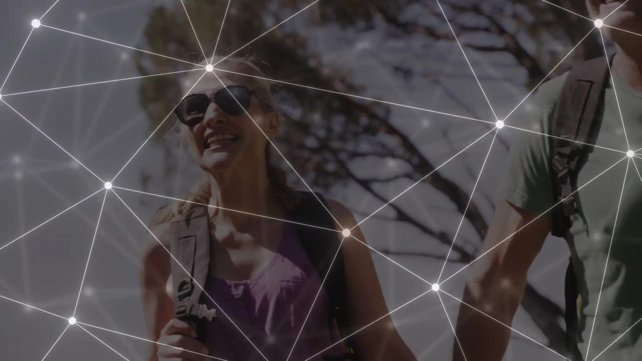Camera panning, woman and man hiking sunlit trail, mesh overlay staying over them mapping tech data
