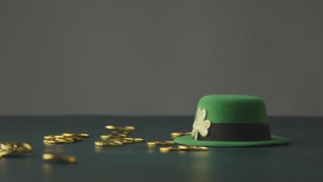 foto de estudio de sombrero de copa de duende verde y monedas de oro que caen para celebrar el día de san patricio