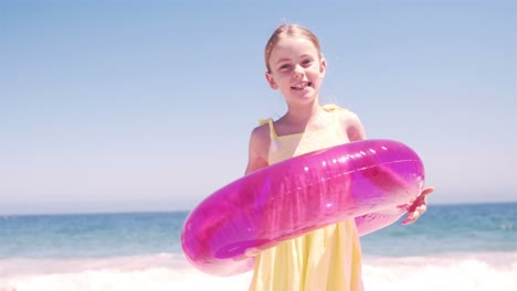 niña jugando con su boya en la playa
