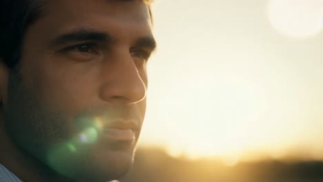 Man looking thoughtfully at sunset.