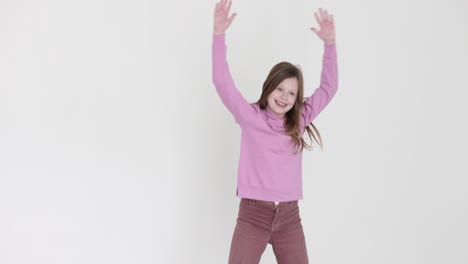 young girl joyfully jumping against a white background
