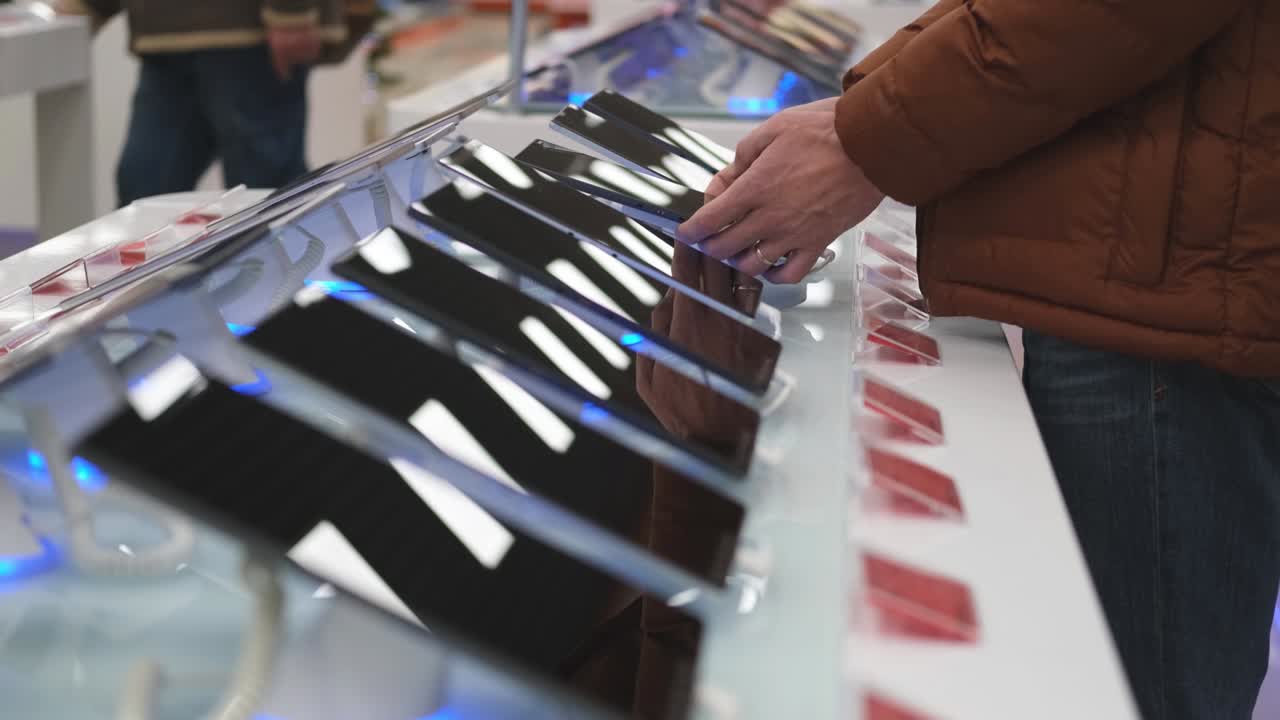 un hombre elige tabletas en un escaparate. compra de tecnología.