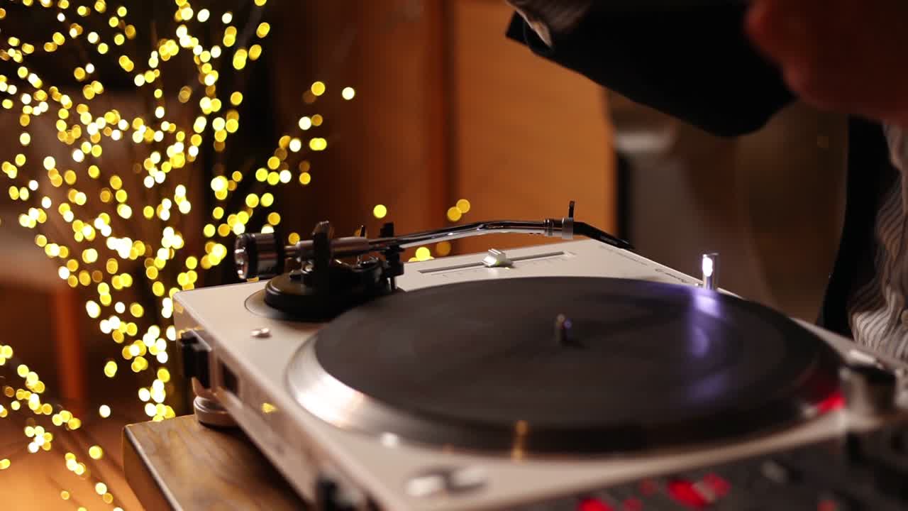dj가 밤에 비닐 레코드를 회전시니다.