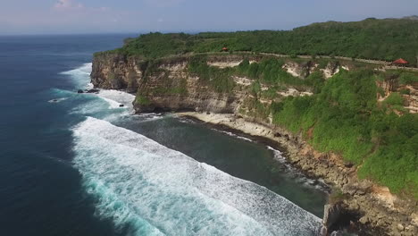 Serene-reversal-drone-shot-of-waves-rolling-onto-the-shoreline-of-a-rocky-coast