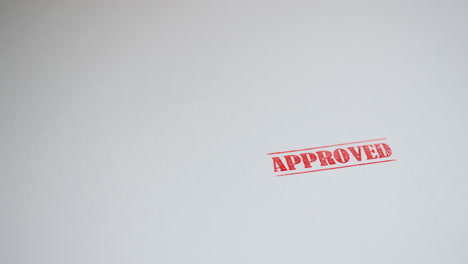 a stamp approved is placed on a sheet of white paper, copyspace compocition