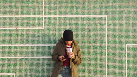 a woman relaxing against a tile wall using