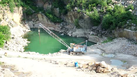 mining in the granite quarry. working mining machine - old crane. mining industry. 4k resolution