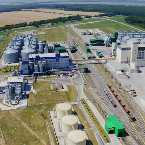 agricultural plant on field. panoramic view on industry on summer landscape. grain elevators for storing cereals in farmland. aerial view.