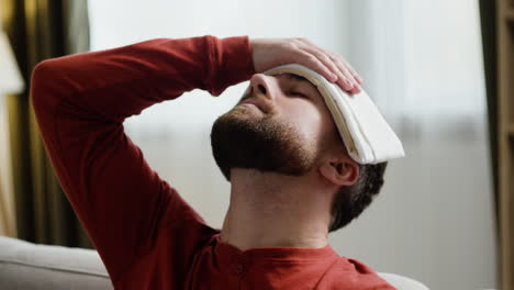 person putting wet cloth on forehead