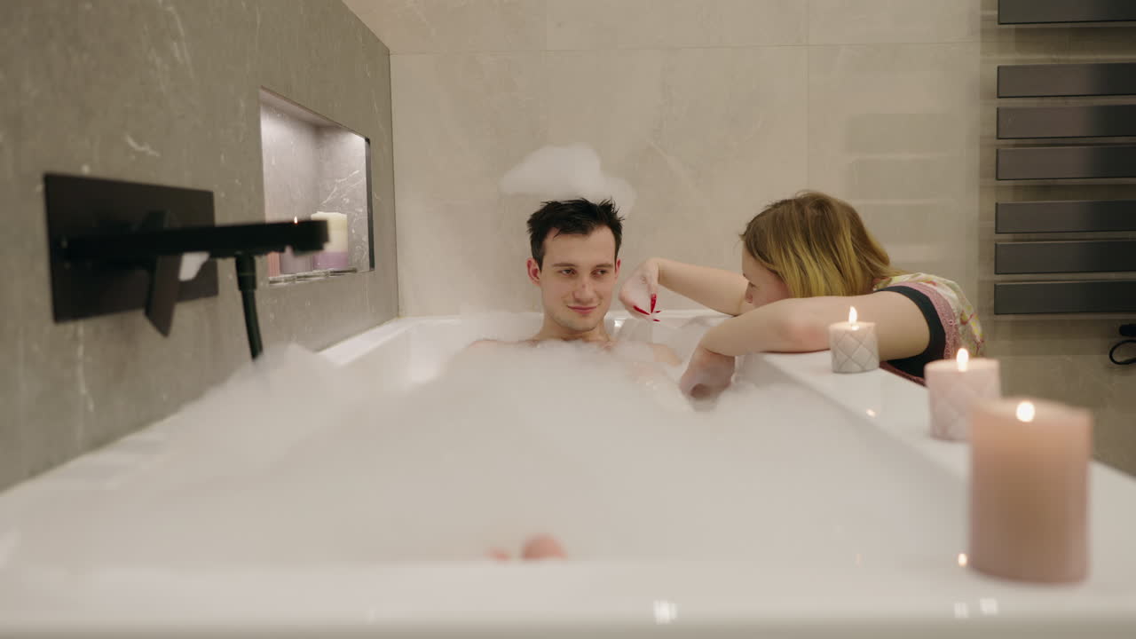 두 사람 이 거품 이 있는 목욕탕 에서 휴식을 취하고 있다