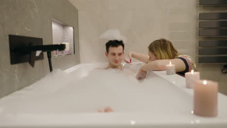 pareja relajándose en un baño espumoso