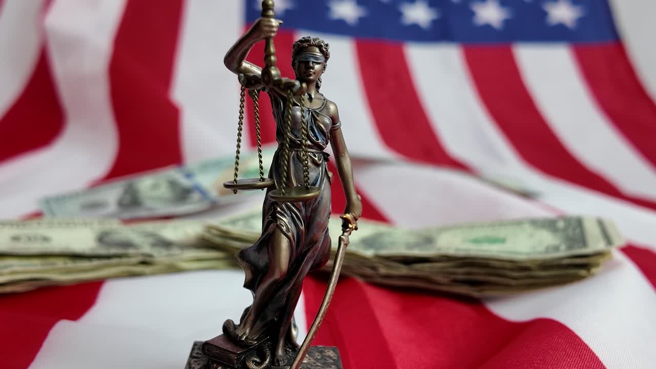 La dea della giustizia è legata dal denaro, le sue bilance inclinate dalla ricchezza, a simboleggiare un sistema in cui il denaro prevale sulla verità e la giustizia è comprata