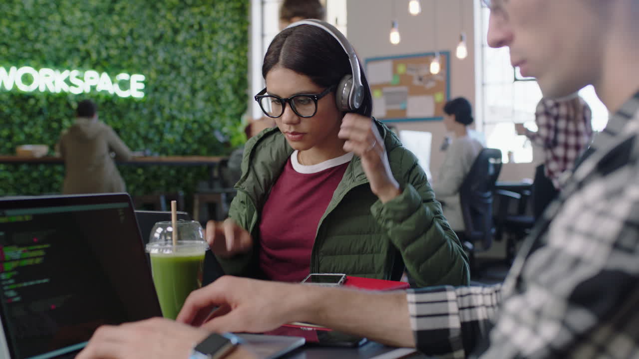 joven ingeniera hispana que usa computadora portátil digital software de codificación discutiendo preguntas de diseño colega compartiendo ideas para un proyecto de aplicación de comunicación colaborando en la oficina