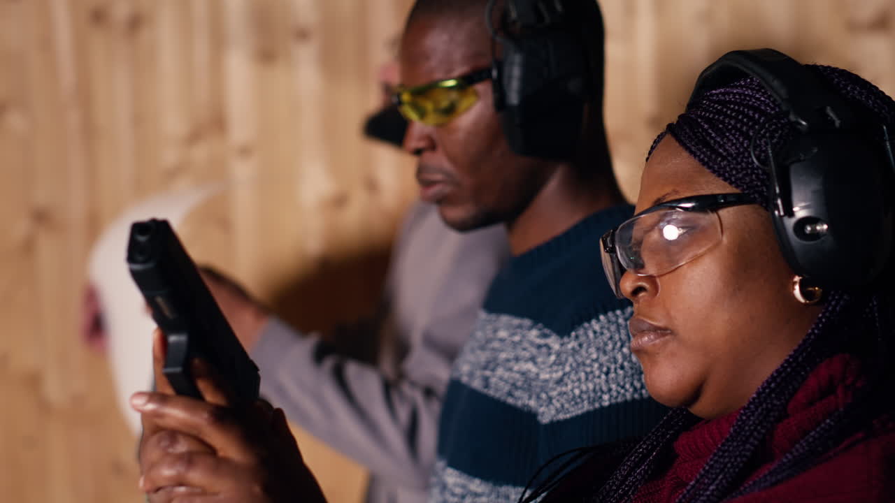 человек на стрельбище занимается стрельбой, смотрит на результаты на бумажной мишени.