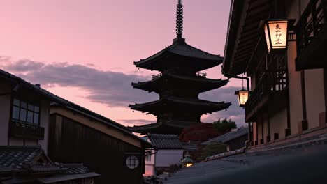 the yasaka pagoda in kyoto stands beautifully illuminated by the warm hues of the setting sun, casting its tranquil silhouette against the sky.