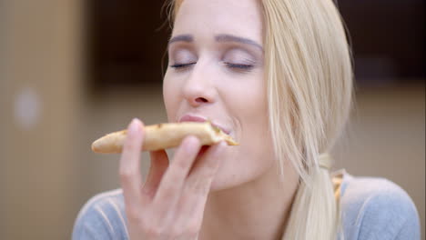 mujer atractiva disfrutando de una rebanada de pizza