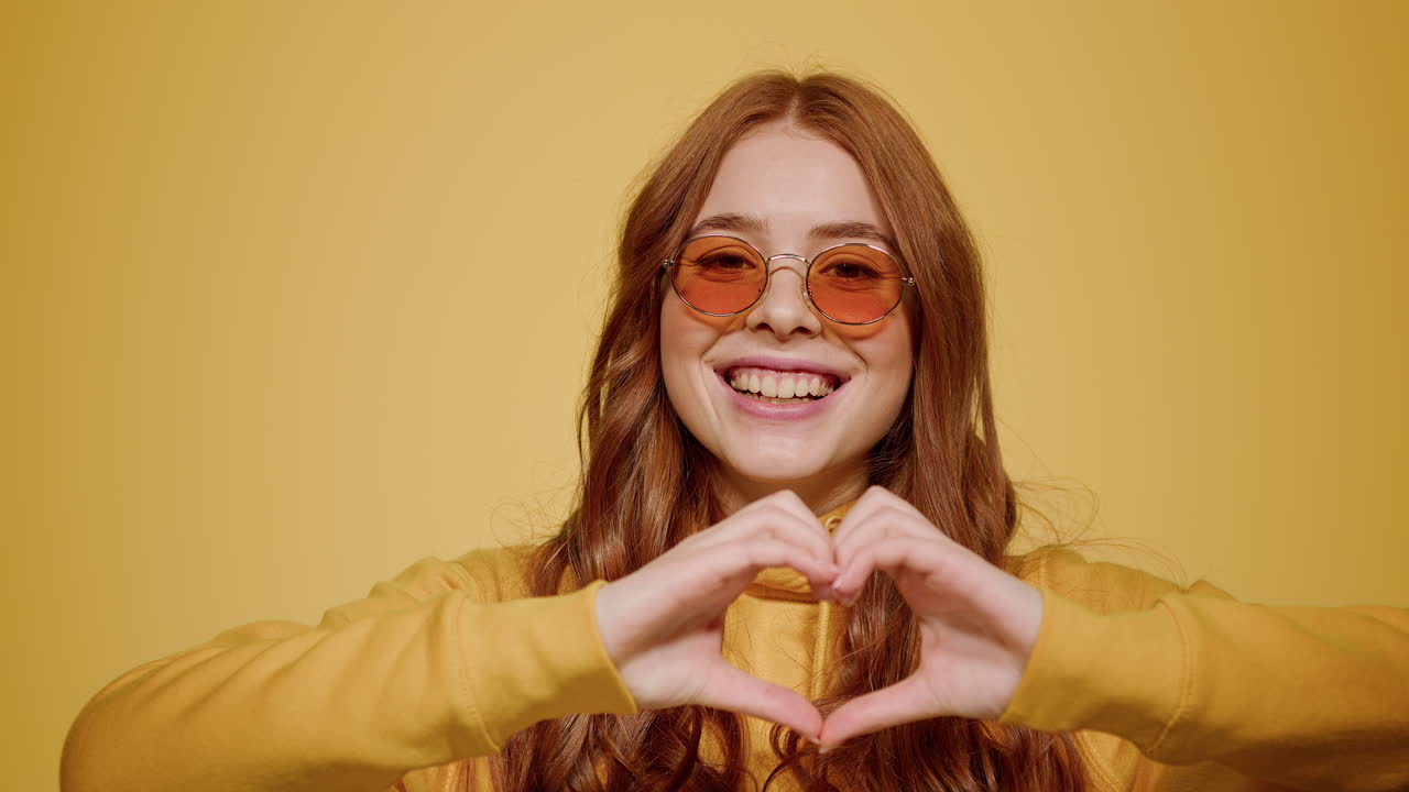 mujer haciendo señas de amor en el interior. chica dulce haciendo gestos con las manos en el estudio.