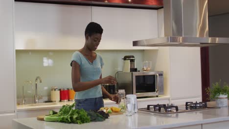 Mujer-Atractiva-Afroamericana-Cortando-Verduras-Para-Batido-En-La-Cocina