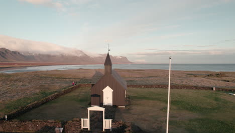 Tight-aerial-parallax-around-Black-Church-of-Budir,-Snaefellsness,-Iceland