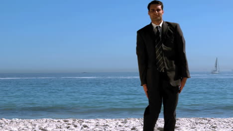 un hombre de negocios gracioso saltando y cruzando la playa.