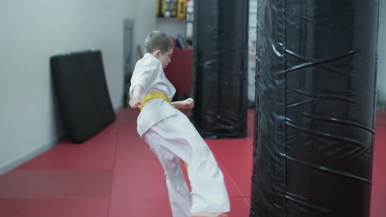 Young martial artists in white gi and yellow belts practicing kudo techniques with focus and determination