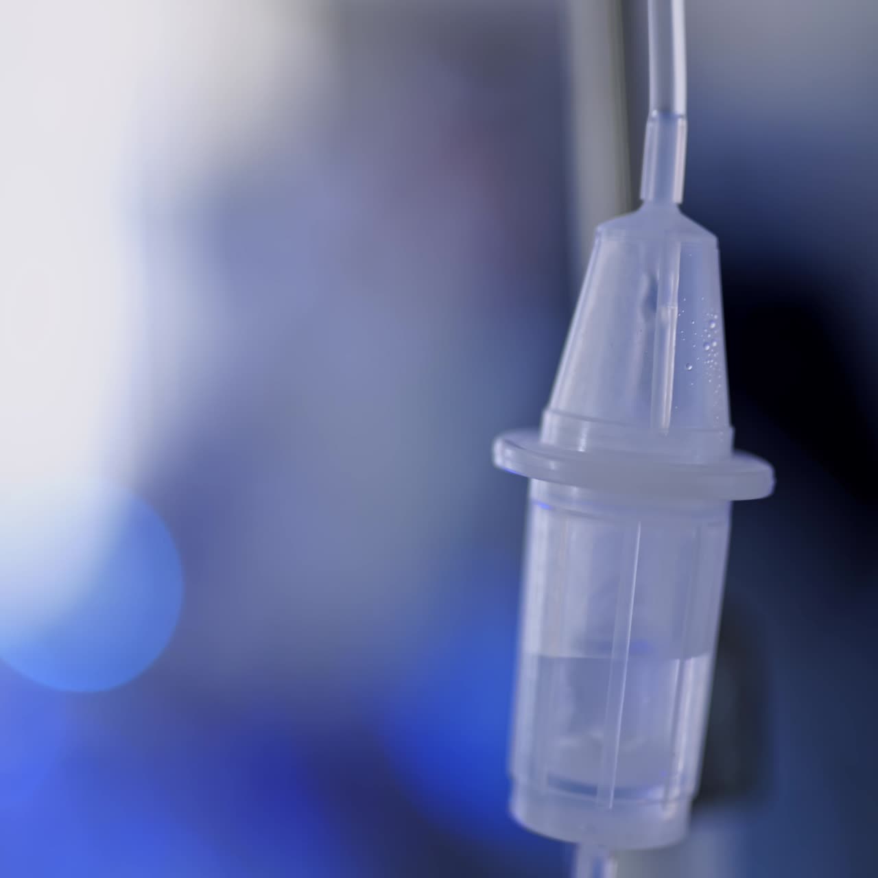 Plastic dropper on blue background. Hospital drop counter in an intensive therapy room. Close-up.