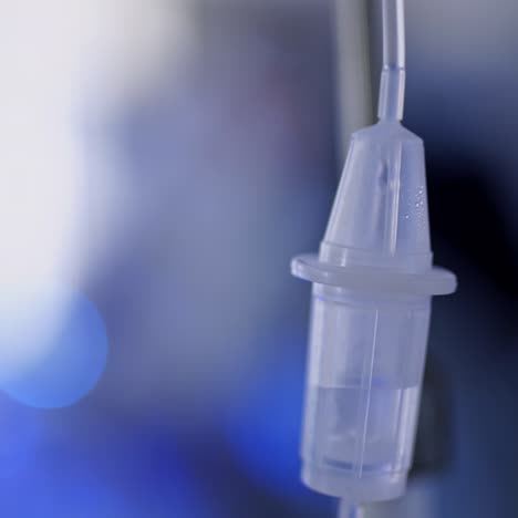 plastic dropper on blue background. hospital drop counter in an intensive therapy room. close-up.