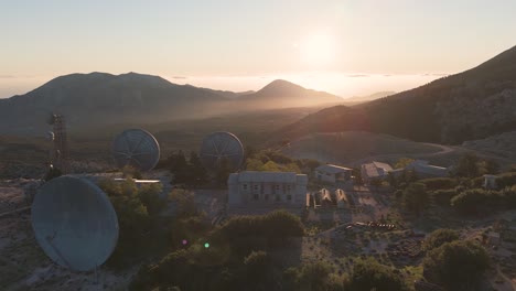 vista al atardecer de una estación de comunicaciones por satélite abandonada en las montañas