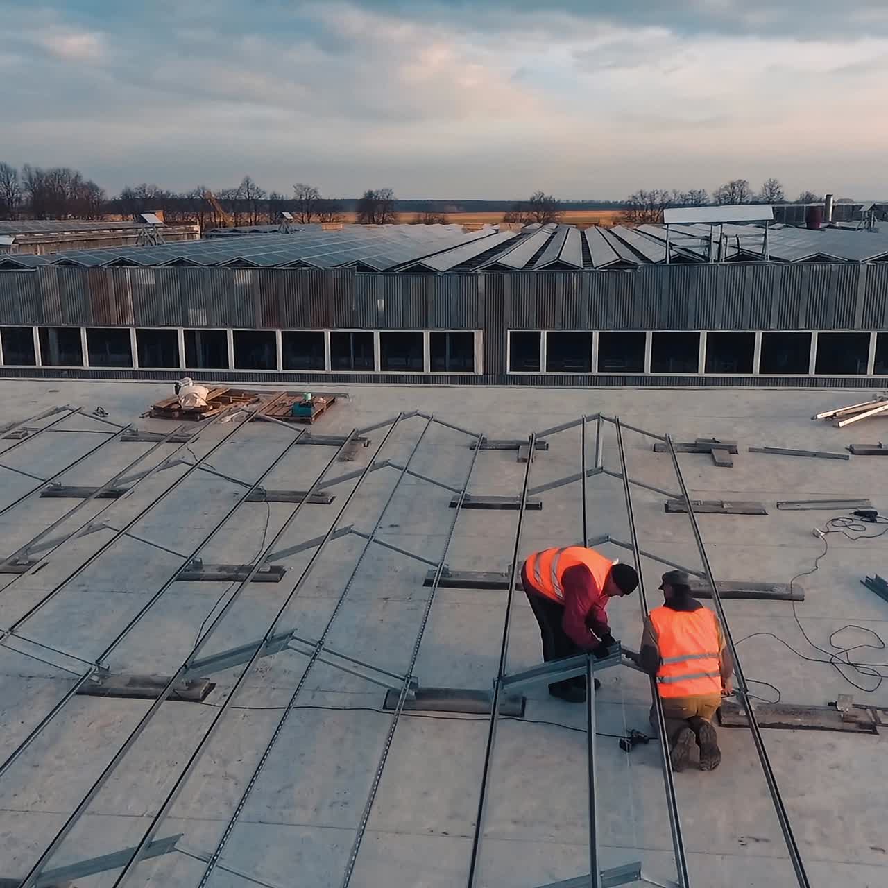 Installation of metal basis for solar panels on roof. Technicians installing new generation photovoltaic solar panels. Aerial view.