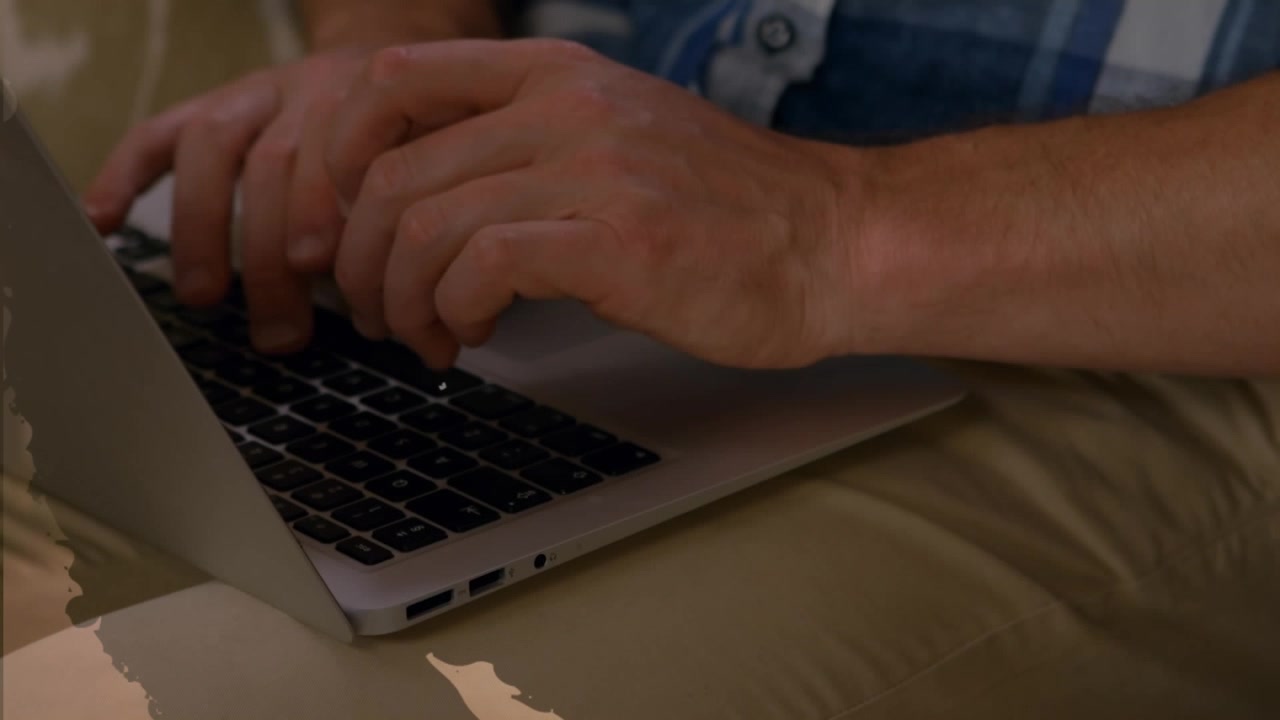 Animation af tal og cifre over hænder, der bruger en bærbar computer.