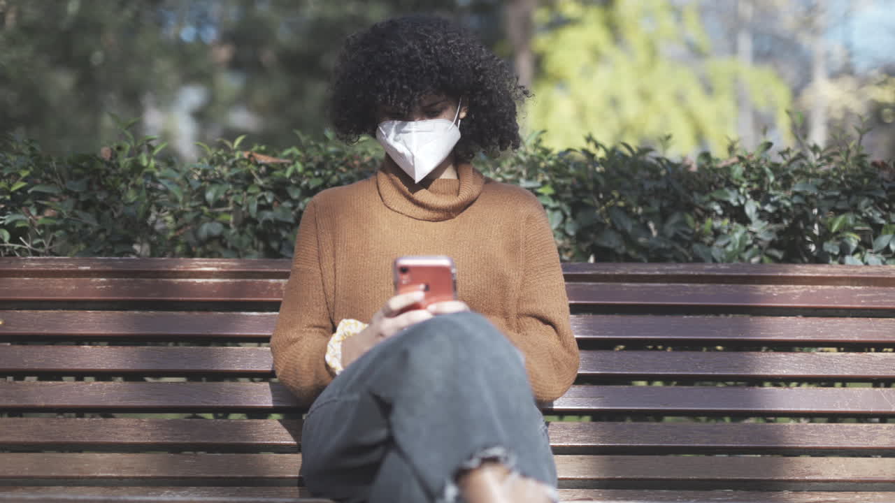 Introvert sort pige sender sms'er midt i pandemien i en park