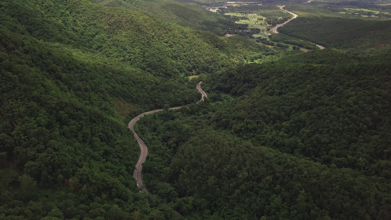 vista aérea de la carretera rural que pasa por la exuberante vegetación y el follaje del paisaje montañoso de la selva tropical
