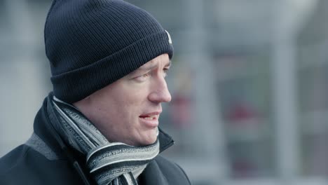 close-up portrait shot of a young man speaking and looking around in downtown rotterdam