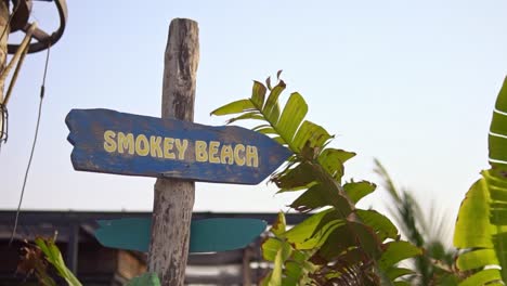 a beach signboard on a public beach in dubai surrounded by decorative plants and gardens in the background