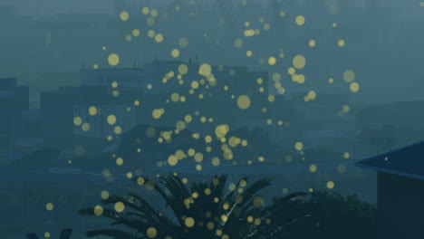 yellow bokeh lights animation over cityscape with palm tree in foreground