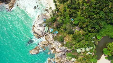 Colorful-houses-on-the-rocky-forested-shore-between-two-sandy-beaches,-Haad-Thong-Reng-and-Haad-Than-Sadet,-Thailand