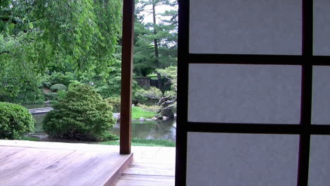 pan from view of japanese garden to shoji panel of japanese house