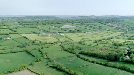 aerial shot over a vast area of green fields in rural britain