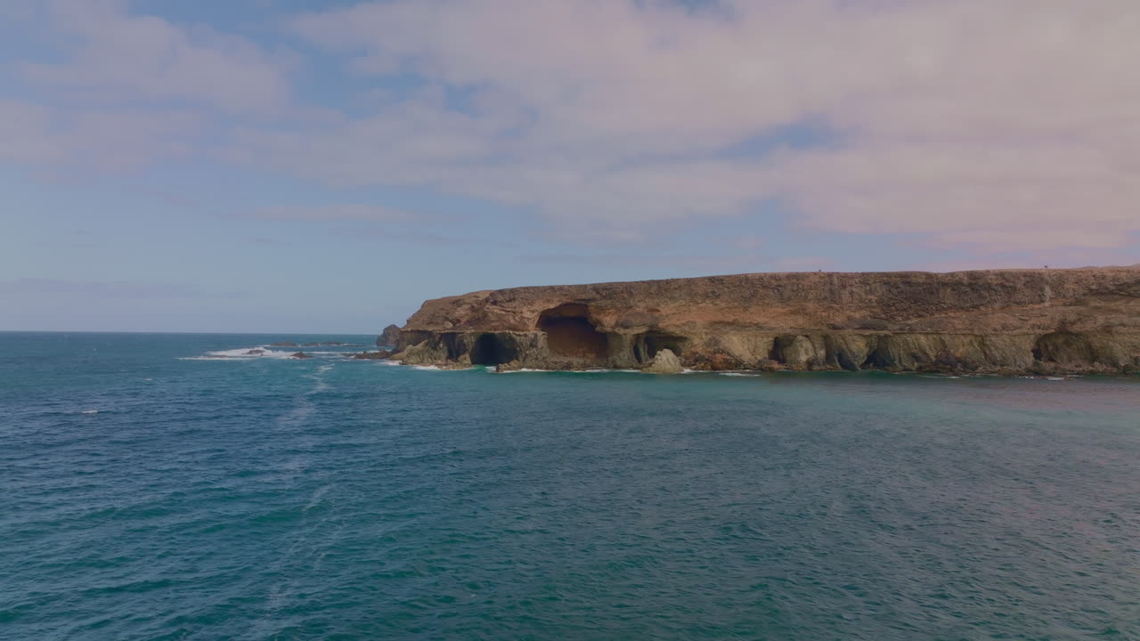 Breathtaking views of Fuerteventura with Lobos Island, Red Flag Beach, kite surfers, sunsets, volcanoes, sand dunes, and wingfoilers in the Canary Islands’ golden light.