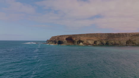 breathtaking views of fuerteventura with lobos island, red flag beach, kite surfers, sunsets, volcanoes, sand dunes, and wingfoilers in the canary islands’ golden light.